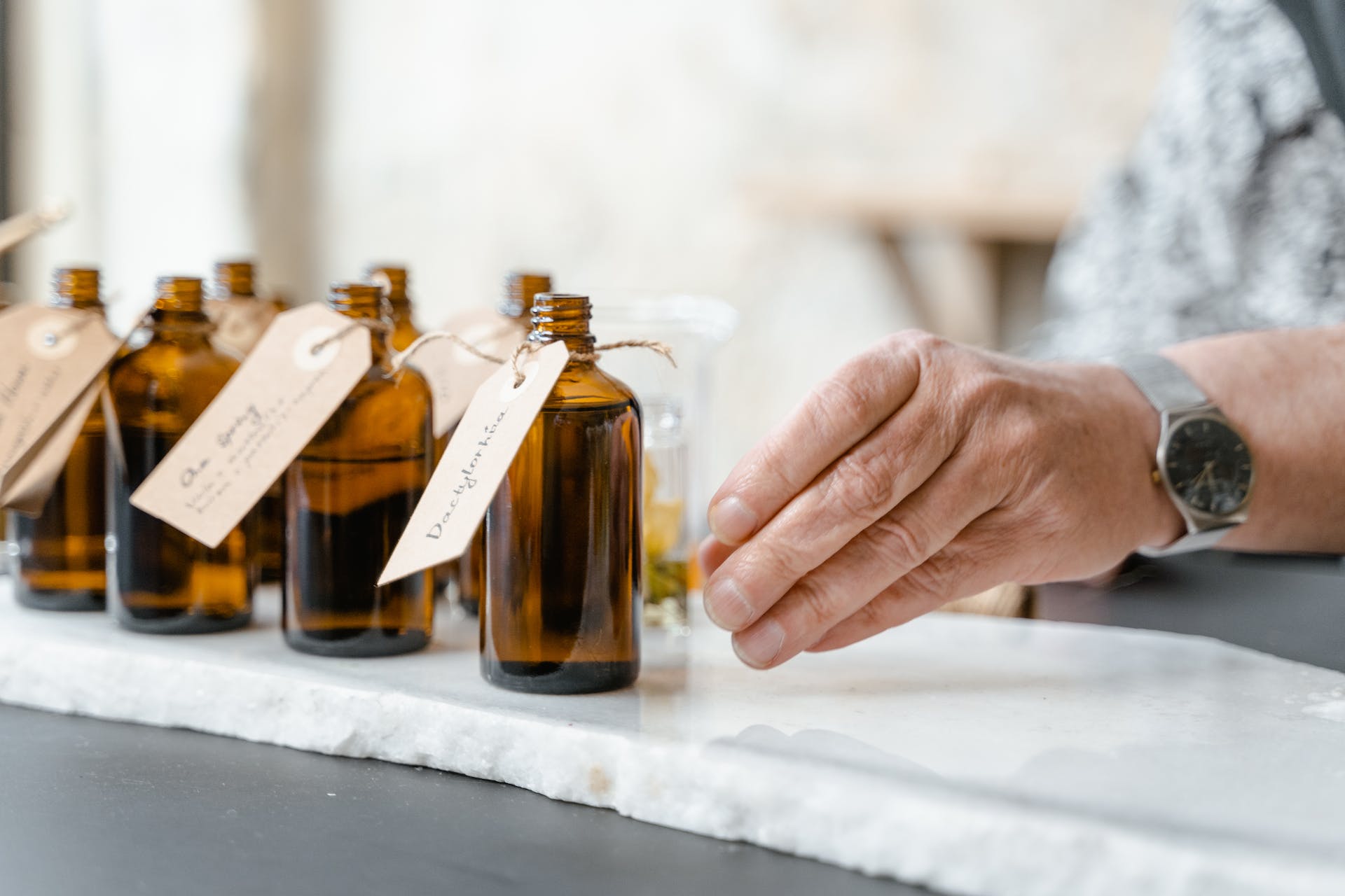 hand reaching for glass, perfume bottles
