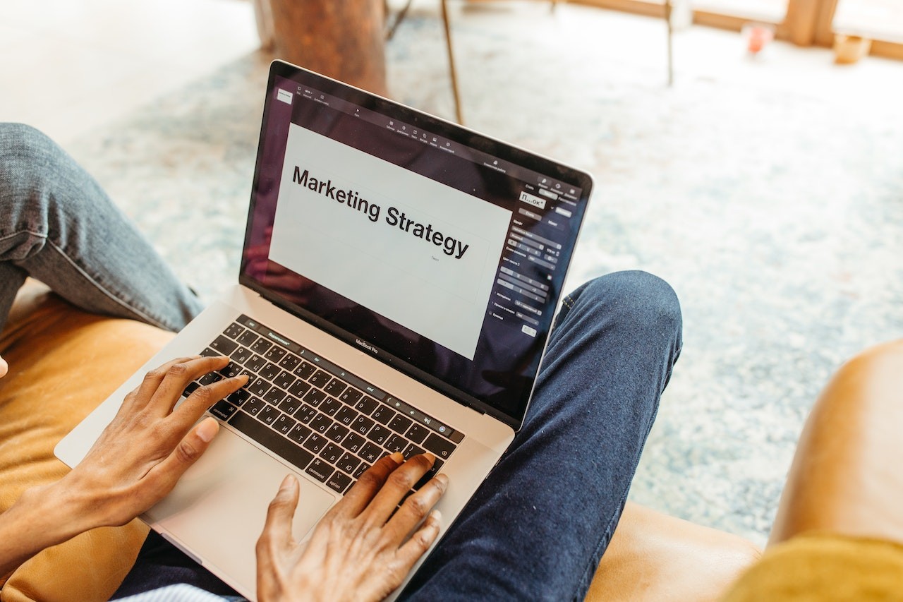 man using laptop with "Marketing Strategy" displayed on the screen