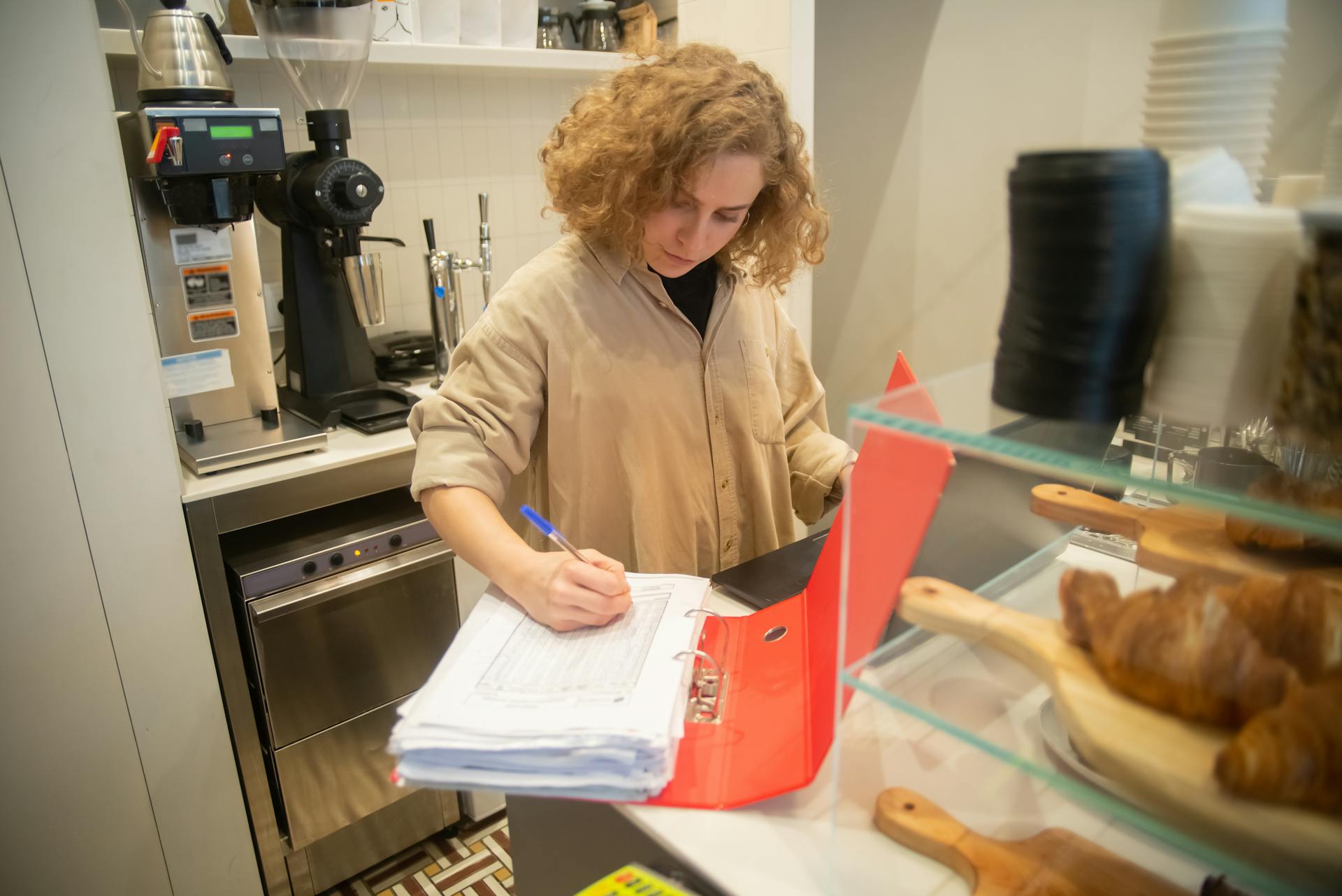 lady updating inventory in binder full of paper
